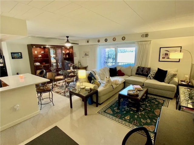 living area with visible vents and ceiling fan