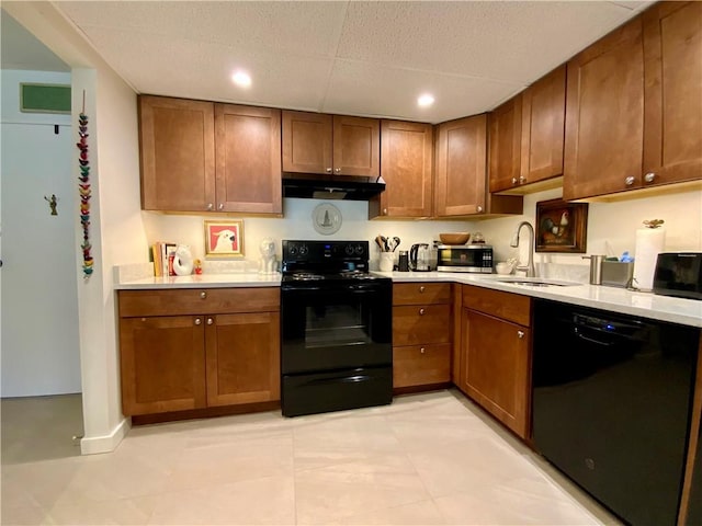 kitchen with a sink, black appliances, light countertops, and under cabinet range hood