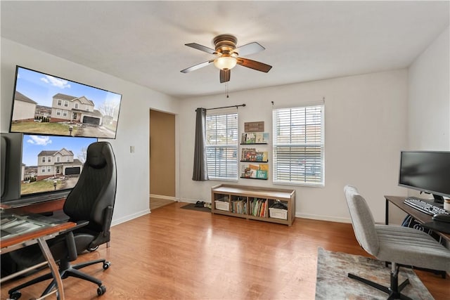 office area with wood finished floors, baseboards, and ceiling fan