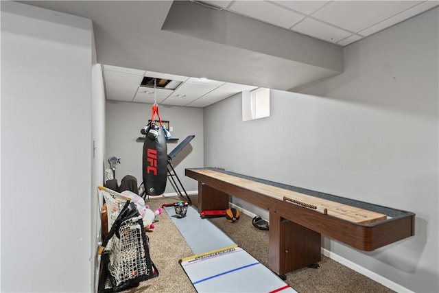 exercise area with a paneled ceiling and baseboards