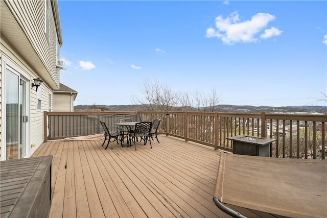 deck with outdoor dining area and a fire pit