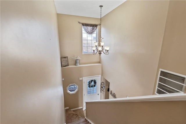 foyer entrance with visible vents and a chandelier