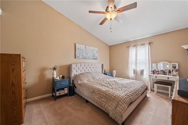 bedroom featuring ceiling fan, vaulted ceiling, baseboards, and light carpet