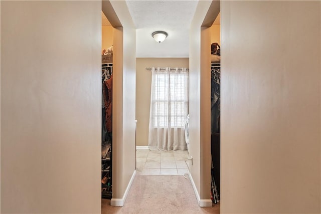 hallway with carpet flooring and baseboards