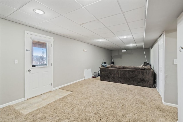 living room featuring a paneled ceiling, baseboards, and carpet floors