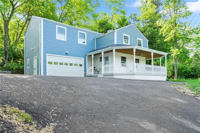 view of front of home featuring a porch, an attached garage, and aphalt driveway