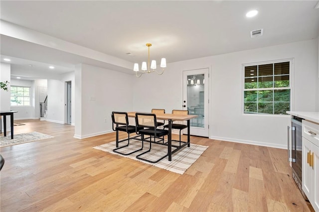 dining area with light wood finished floors, visible vents, stairway, recessed lighting, and an inviting chandelier