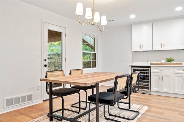 dining room featuring beverage cooler, visible vents, recessed lighting, and light wood-style floors