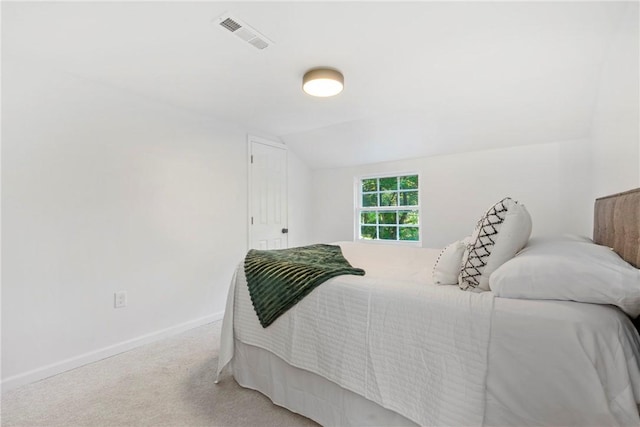 carpeted bedroom featuring vaulted ceiling, baseboards, and visible vents