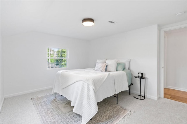 carpeted bedroom featuring baseboards and visible vents