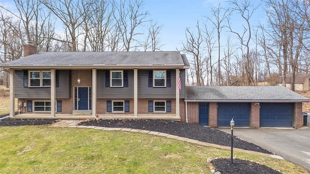 raised ranch with brick siding, a garage, and driveway