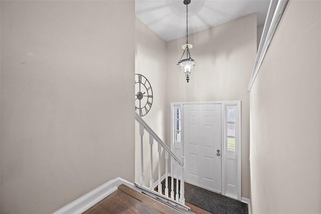 foyer featuring baseboards, dark wood finished floors, and stairs