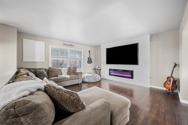 living room with a glass covered fireplace, baseboards, and wood finished floors