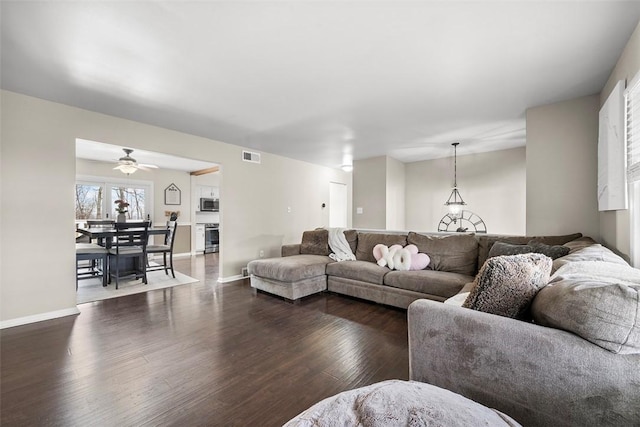 living room with visible vents, ceiling fan, dark wood-type flooring, and baseboards