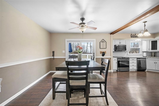 dining room with ceiling fan with notable chandelier, baseboards, and dark wood-style flooring