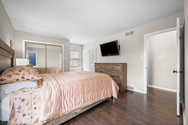 bedroom with visible vents, baseboards, and wood finished floors