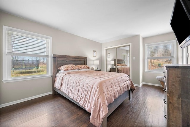 bedroom featuring a closet, baseboards, and dark wood finished floors