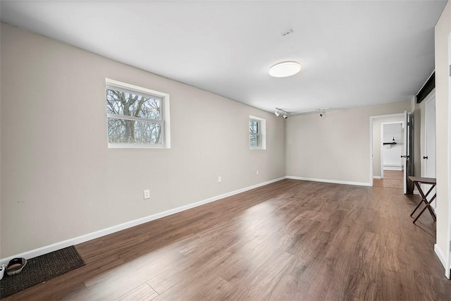 unfurnished room featuring baseboards and wood finished floors