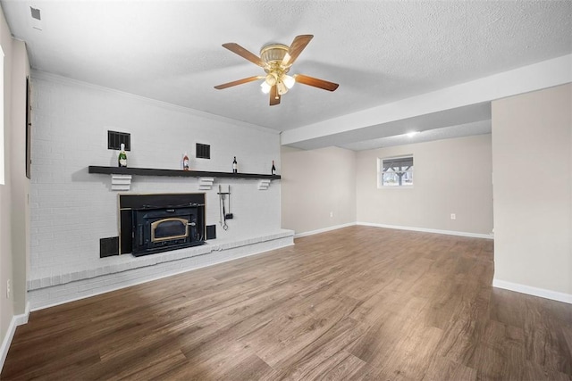 unfurnished living room featuring ceiling fan, wood finished floors, baseboards, and a textured ceiling