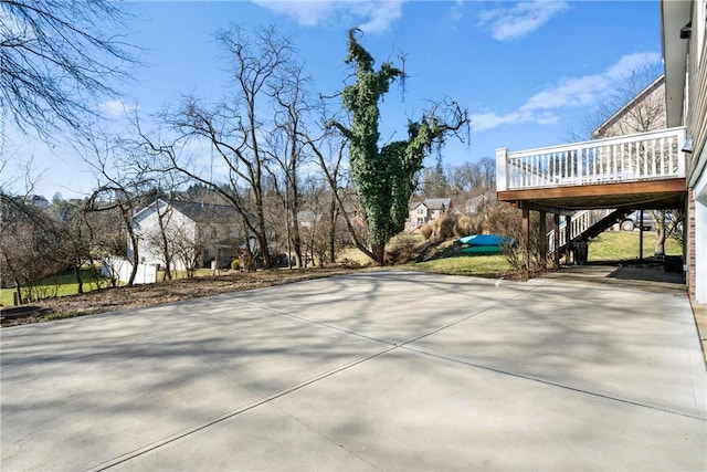 view of patio with stairs, a wooden deck, and driveway