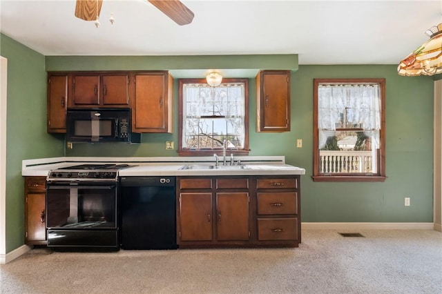 kitchen with visible vents, baseboards, light colored carpet, and black appliances