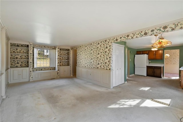 spare room featuring wallpapered walls, light colored carpet, and ornamental molding