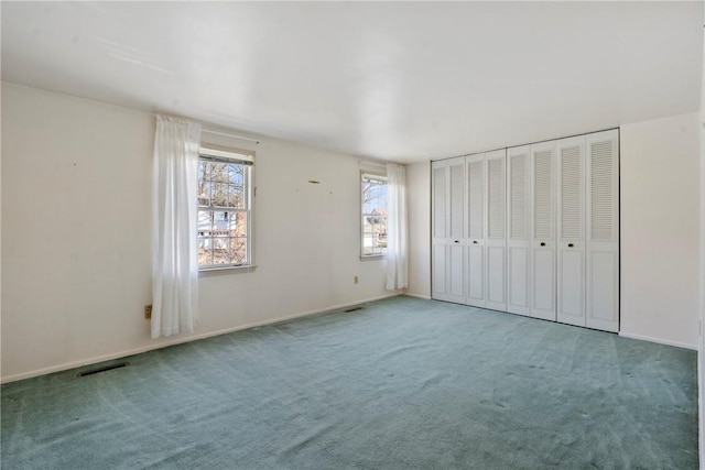 unfurnished bedroom featuring carpet flooring, baseboards, and visible vents