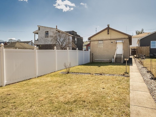 view of yard featuring entry steps and a fenced backyard