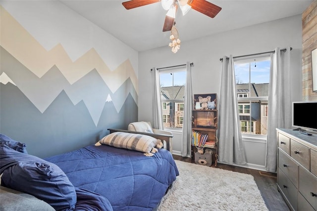 bedroom featuring baseboards, a ceiling fan, and dark wood-style flooring