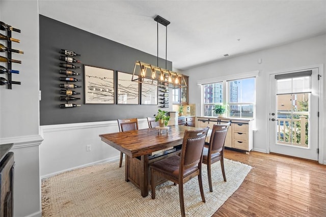 dining room featuring light wood-type flooring and a notable chandelier