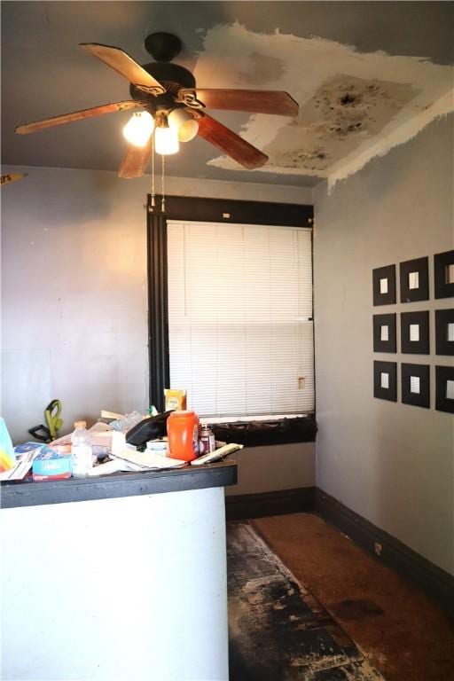 interior space with baseboards and a ceiling fan