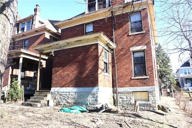 exterior space featuring brick siding and a porch