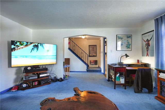 living area with arched walkways, carpet floors, and stairs