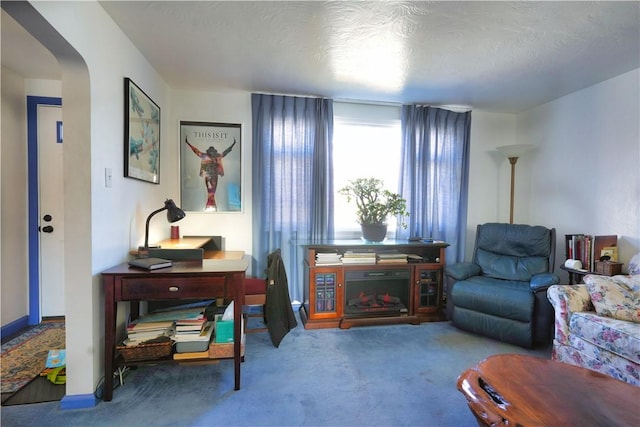 carpeted living area with baseboards and arched walkways