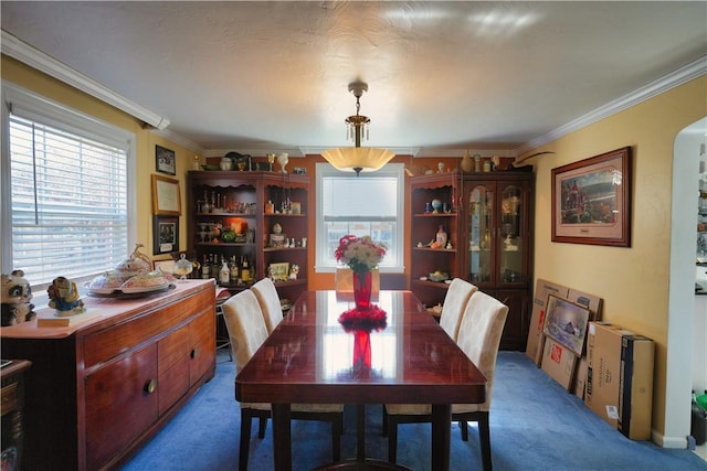 dining space with ornamental molding and carpet flooring