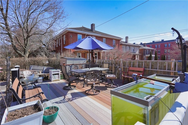 wooden deck featuring a jacuzzi and outdoor dining space