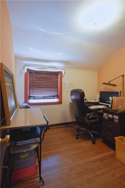 office with vaulted ceiling and hardwood / wood-style flooring