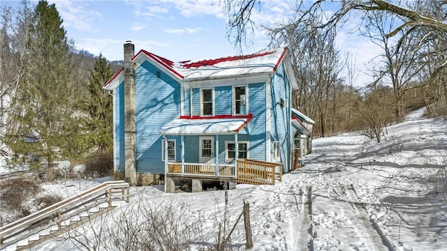 view of front of property with a porch and a chimney