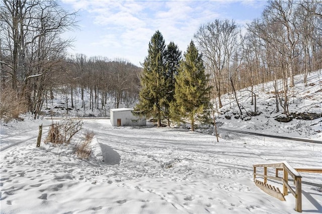 yard layered in snow featuring an outdoor structure