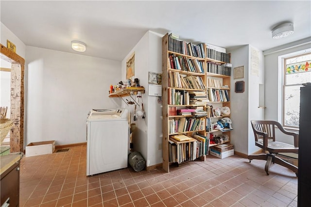 living area featuring washer / dryer and baseboards