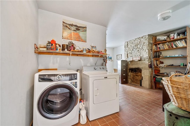 clothes washing area with laundry area, washing machine and dryer, and a fireplace