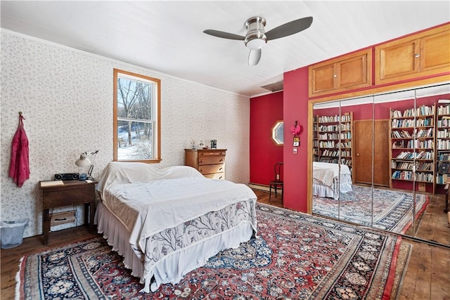 bedroom with a ceiling fan, a baseboard radiator, wallpapered walls, wood-type flooring, and crown molding