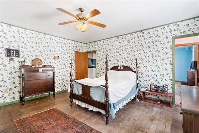 bedroom featuring baseboards, hardwood / wood-style floors, a ceiling fan, and wallpapered walls