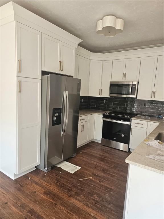 808 10th St, New Stanton, PA 15697 - kitchen with stainless steel appliances, white cabinets, dark wood finished floors, and decorative backsplash