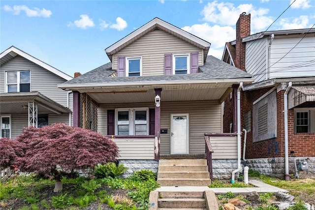 bungalow-style house featuring covered porch and a shingled roof