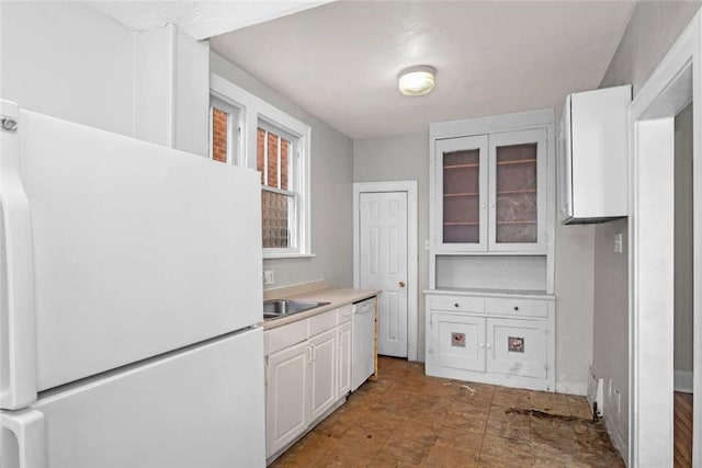 kitchen featuring white cabinetry, white appliances, glass insert cabinets, and light countertops