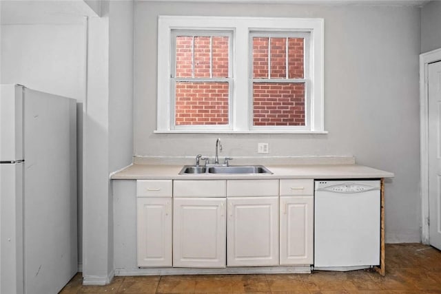 kitchen with white cabinetry, white appliances, light countertops, and a sink