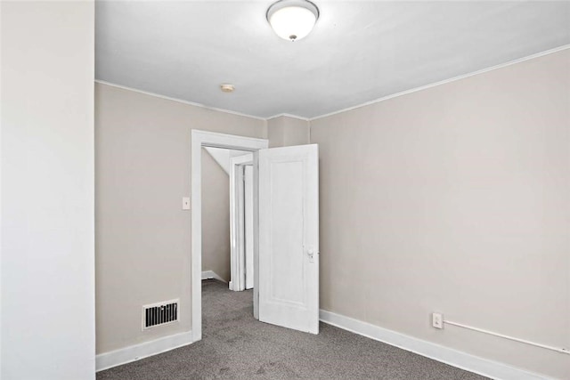 carpeted empty room with crown molding, baseboards, and visible vents