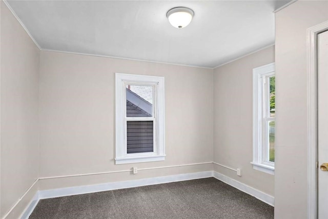 unfurnished room with baseboards and dark carpet