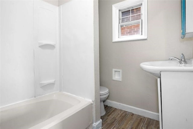 bathroom with baseboards, toilet, and wood finished floors